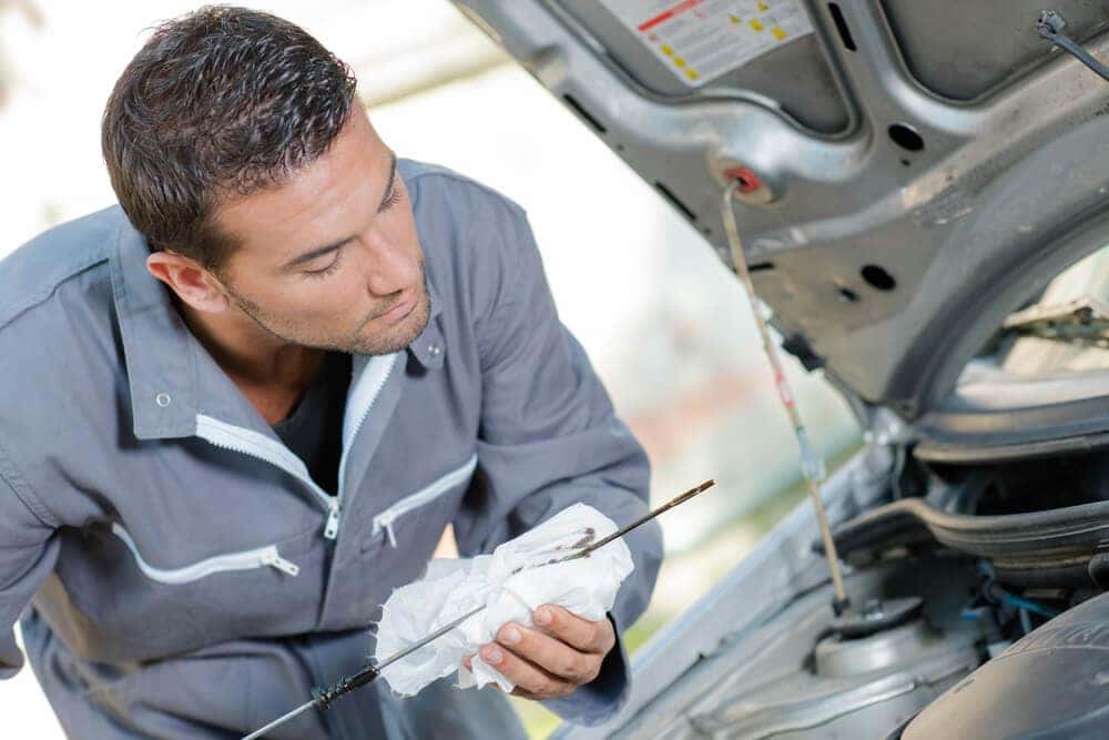 Service technician checking oil levels