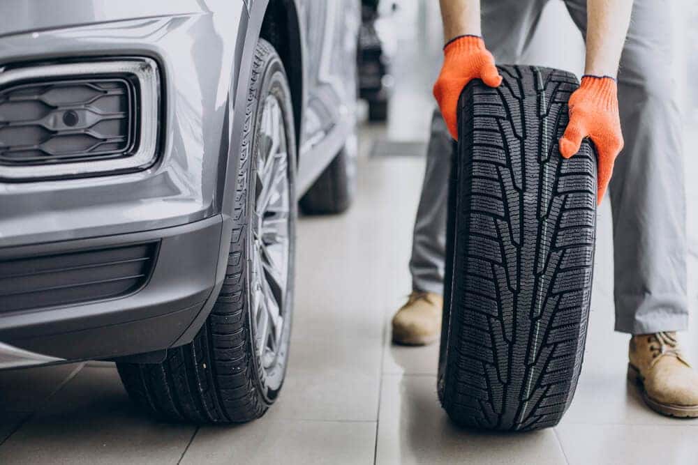Service technician rotating tires