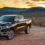 Black 2019 RAM 1500 parked on gravel with mountains in the background