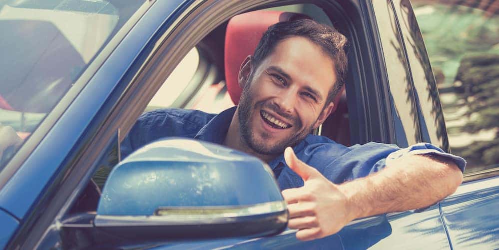 Man Giving a Thumbs Up After Buying a Used Car