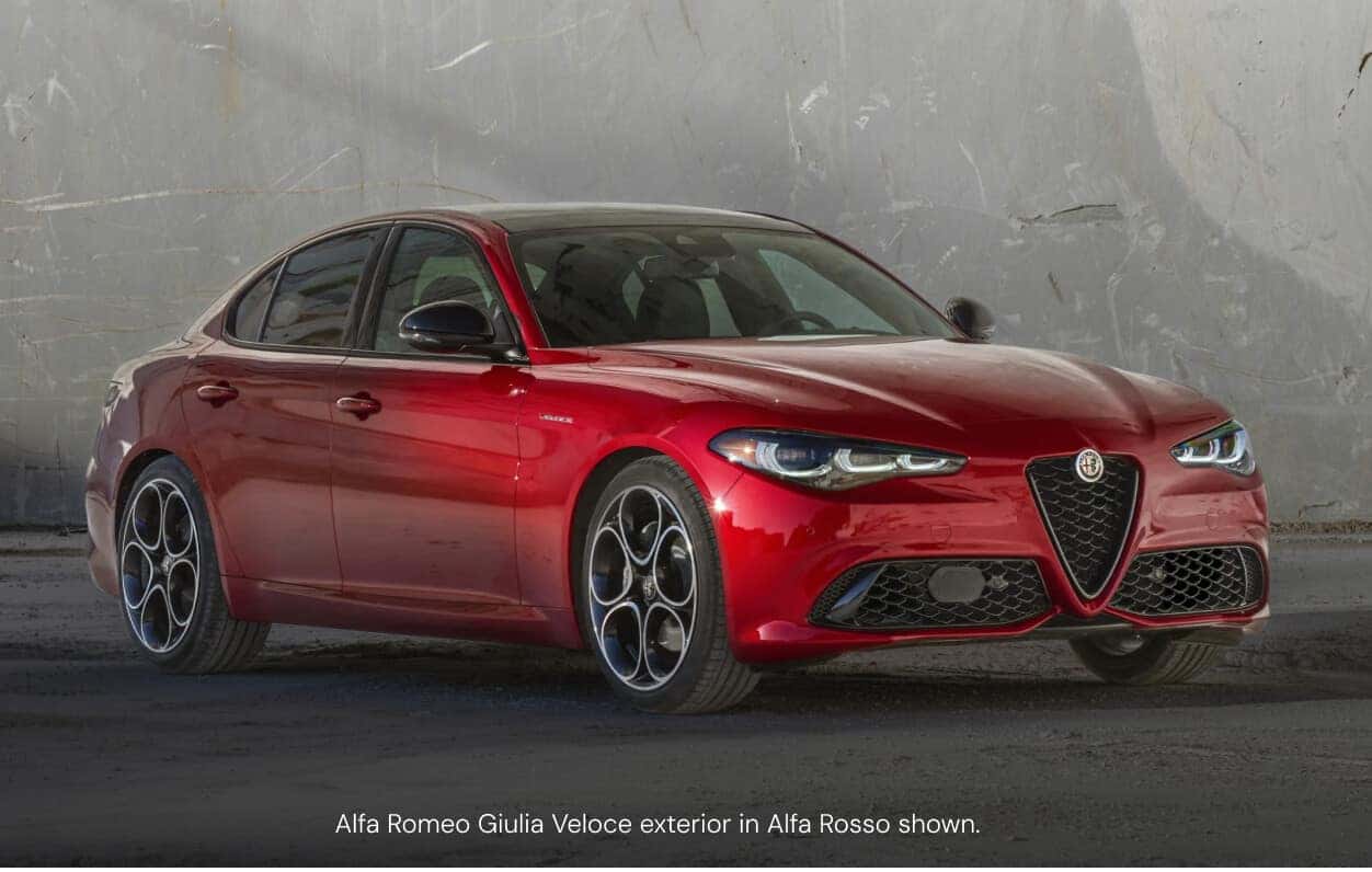 Three-quarter front view of an Alfa Romeo Giulia Veloce in Alfa Rosso showcasing its signature alloy wheels.