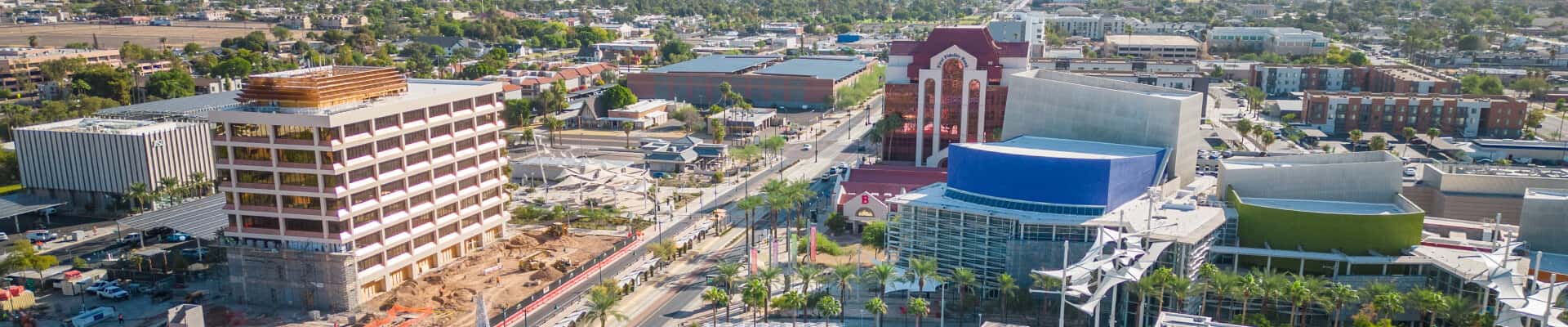 Aerial view of a modern downtown with buildings, offices, palm-lined streets and surrounding neighborhoods.