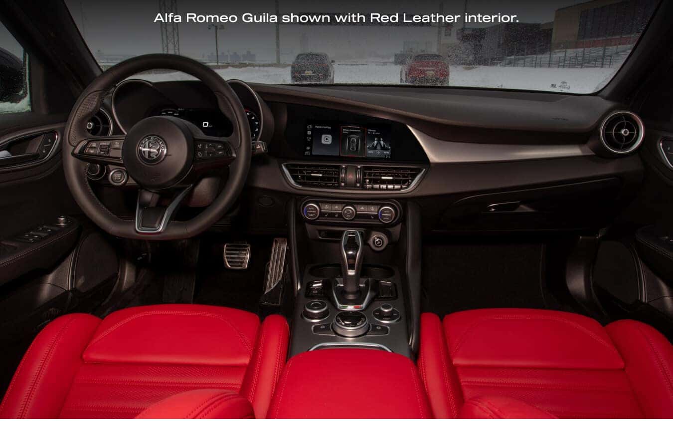 Dashboard view looking through the windshield from inside a 2026 Alfa Romeo Giulia with Red Leather interior.