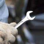 close up of gloved hand holding wrench