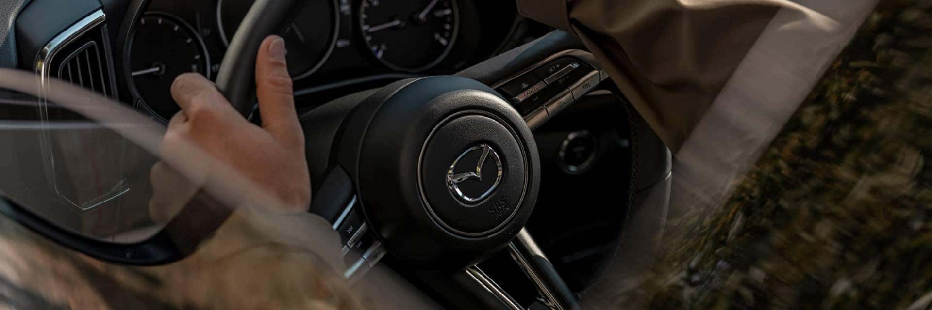 2025 Mazda CX-50 Hybrid interior shot of steering wheel with someone driving