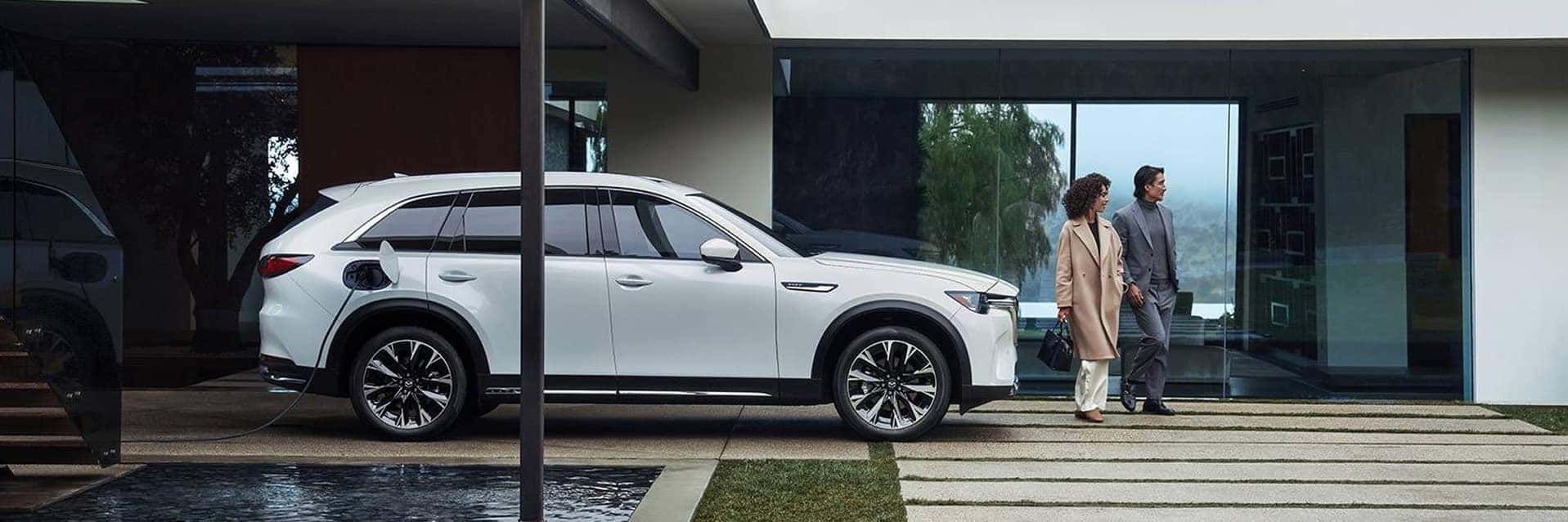 happy couple standing next to 2025-mazda-cx-90