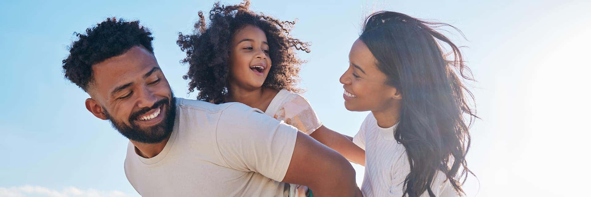 family of three smiling and playing
