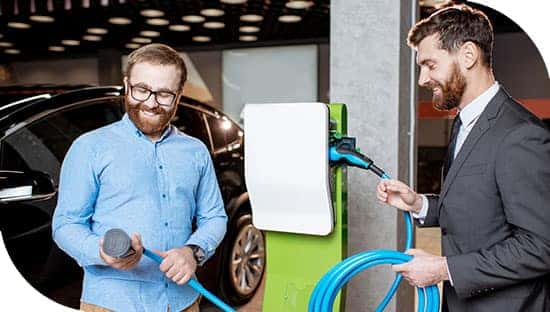 Dos personas hablan de un cargador para vehículos eléctricos