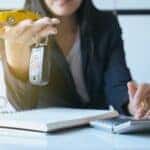 Woman holding a yellow toy car and a keyfob