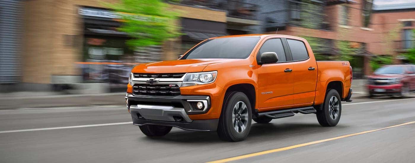 An orange 2021 Chevy Colorado Z71 is shown from the front at an angle after the owner searched for how to 'sell my car'.