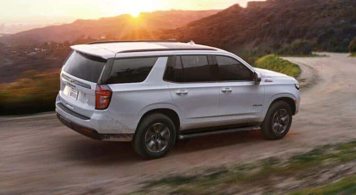 A white 2021 Chevy Tahoe is shown from the side after leaving a dealer that has a used Chevy Tahoe for sale.