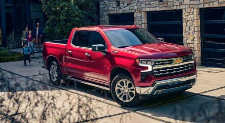 A red 2024 Chevy Silverado 1500 Z71 is shown parked on a driveway after visiting a Chevy truck dealer.