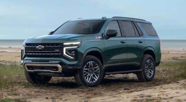 A green 2025 Chevy Tahoe Z71 is parked on sand.