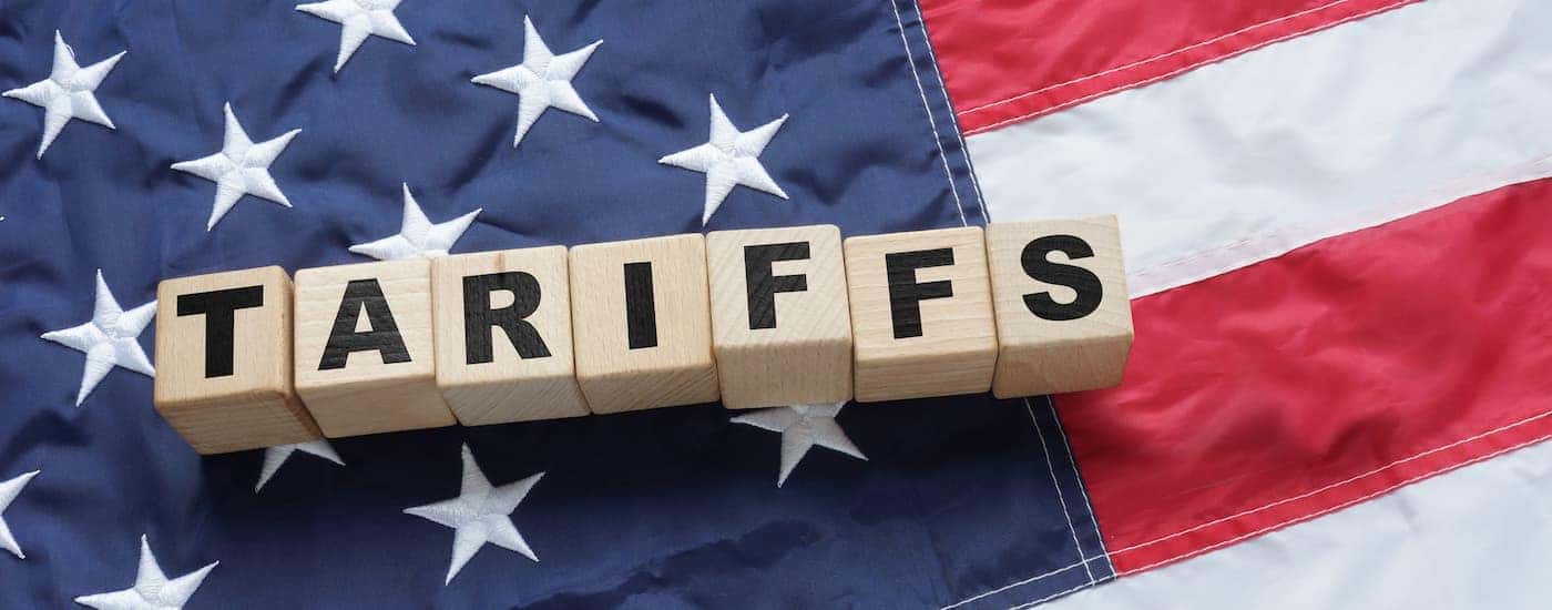 Letter blocks spelling out 'tariffs' on an American flag.