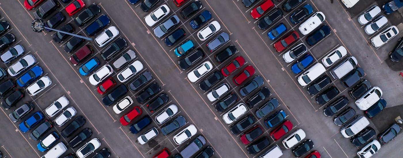 Rows of colorful vehicles for sale at a car dealership.