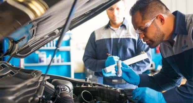 Acura service tech looking at engine