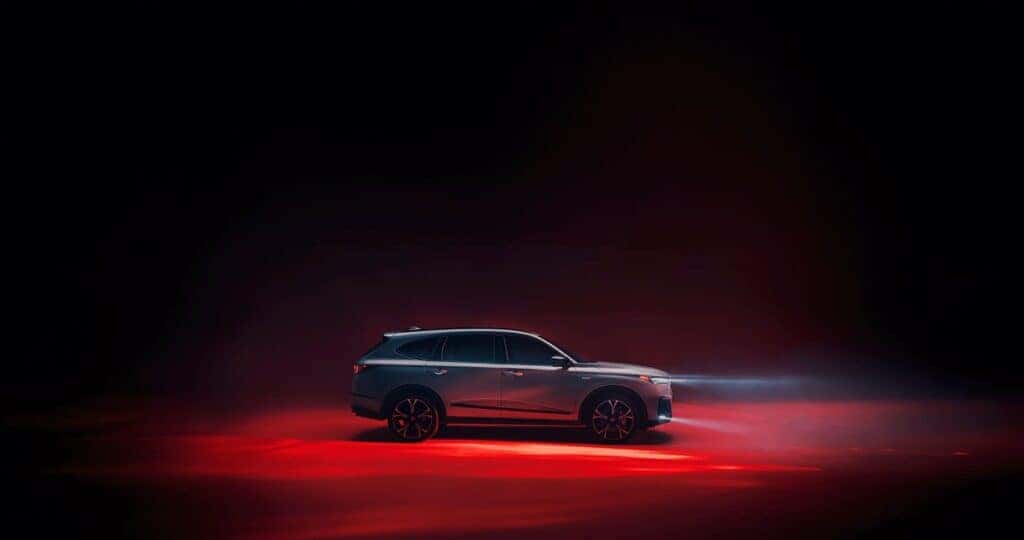 Acura MDX dimensions being shown off in a dark studio with red floor