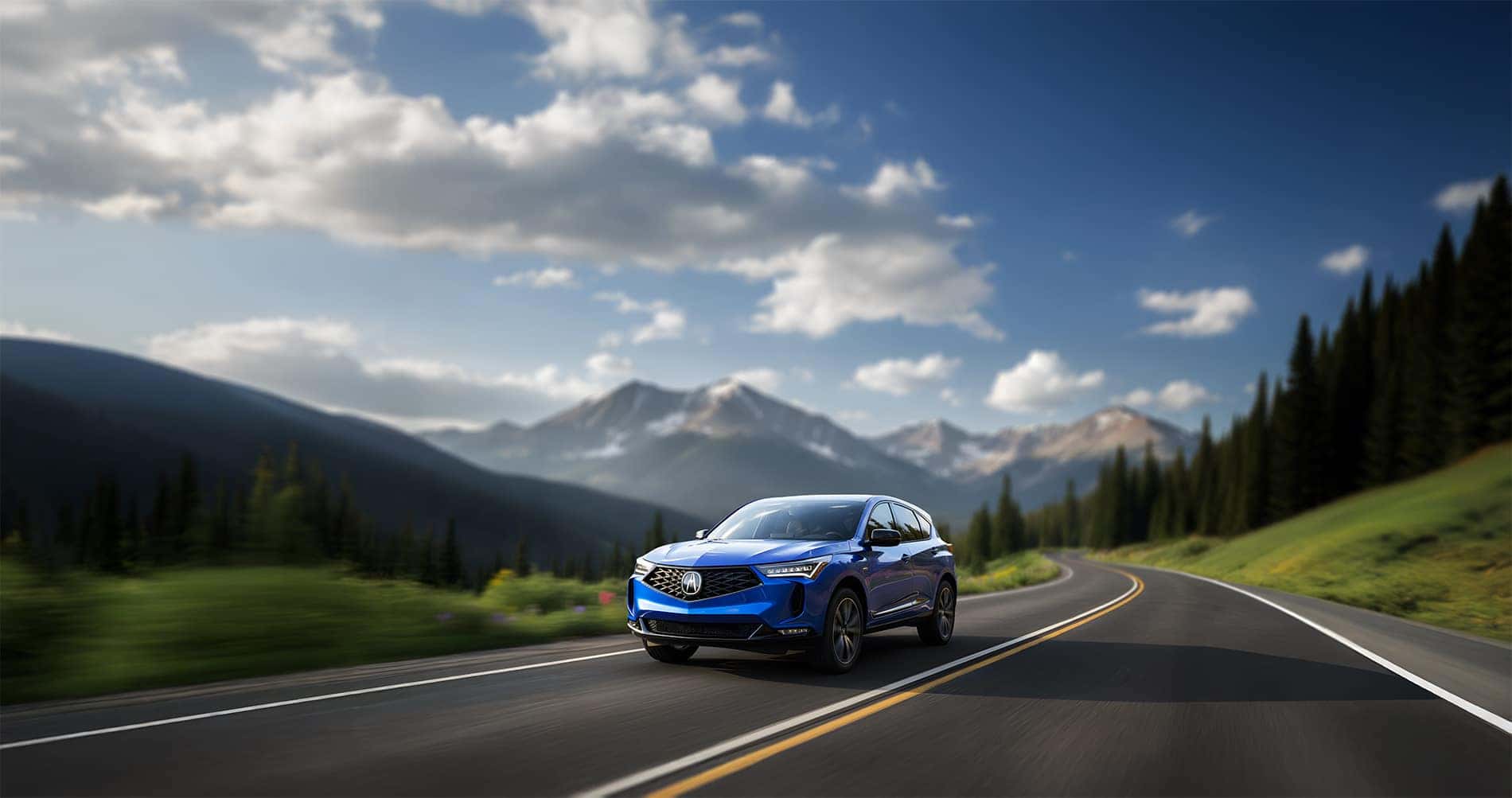 2026 Acura RDX Color of APEX BLUE PEARL driving through the Rocky Mountains