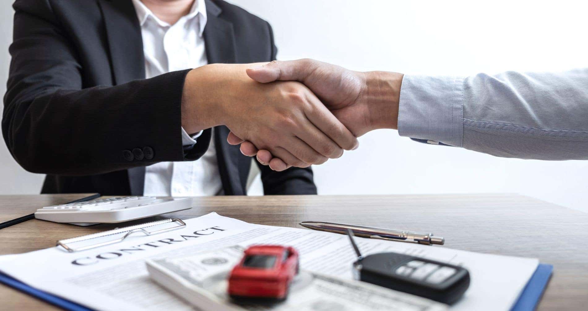 Men shaking hands after signing contract on an Acura lease deal