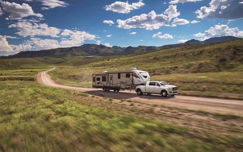 Ram 2500 towing camper on dirt road