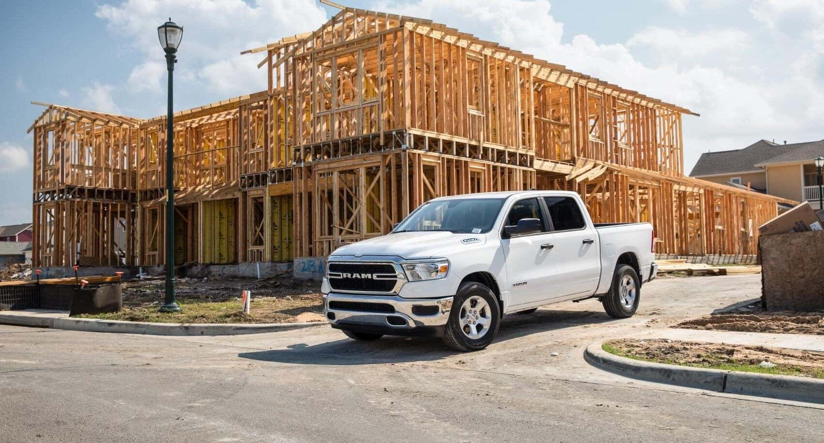White Ram 1500 next to house construction site