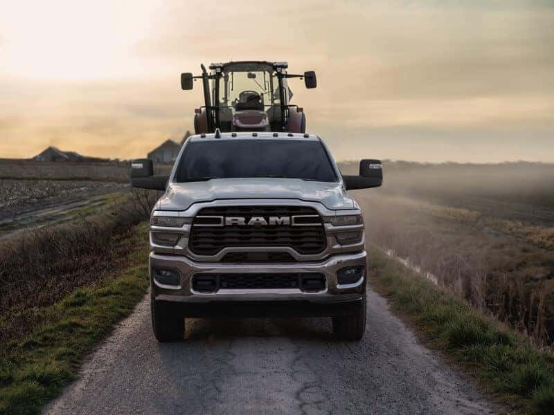 A 2025 Ram 2500 drives towards us towing farming equipment.