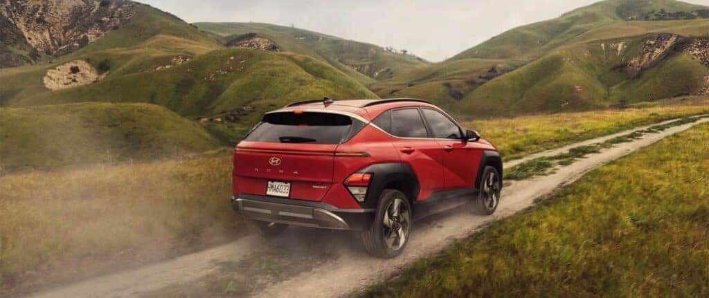 Rear view of a 2026 Hyundai Kona in red driving in an off-road setting