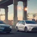 Blue and white Toyota Corolla under highway at sunrise