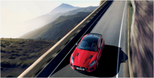 Red Jaguar F-TYPE SVR speeding down road