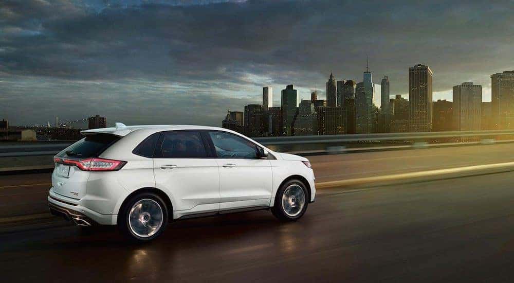 White 2018 Ford Edge on highway in front of cityscape