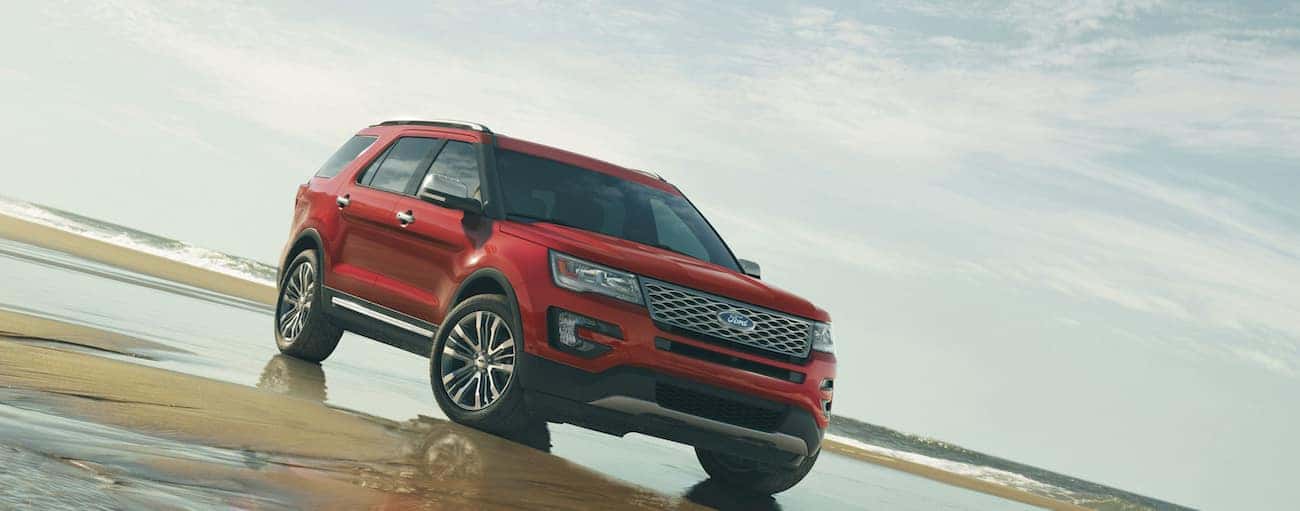 A red 2019 Ford Explorer parked on a sandy beach