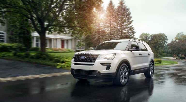 White 2019 Ford Explorer driving through suburb