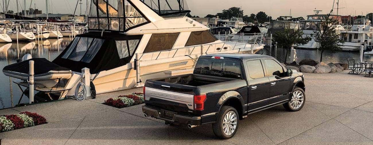A black 2019 Ford F-150 parked next to a large yacht 