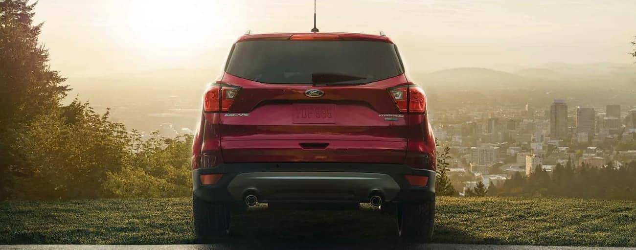 A red 2019 Ford Escape is parked about a city at a time of day with low sun.