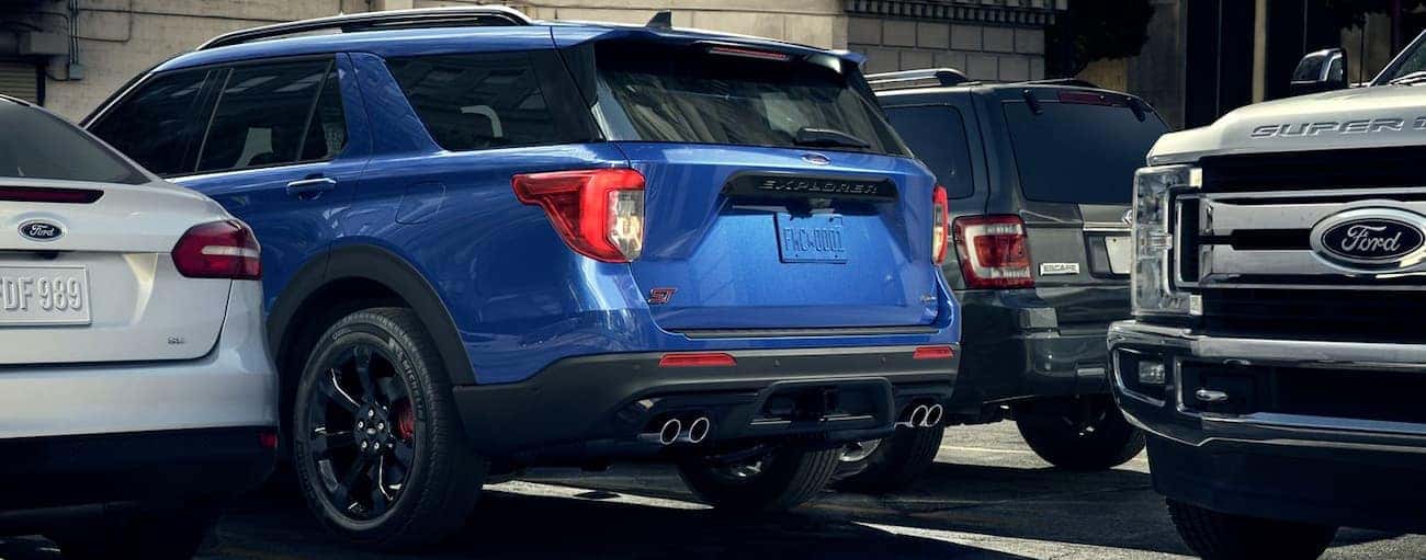 A blue 2020 Ford Explorer ST is backing out of a spot as a truck passes by in a Cincinnati, OH parking lot.