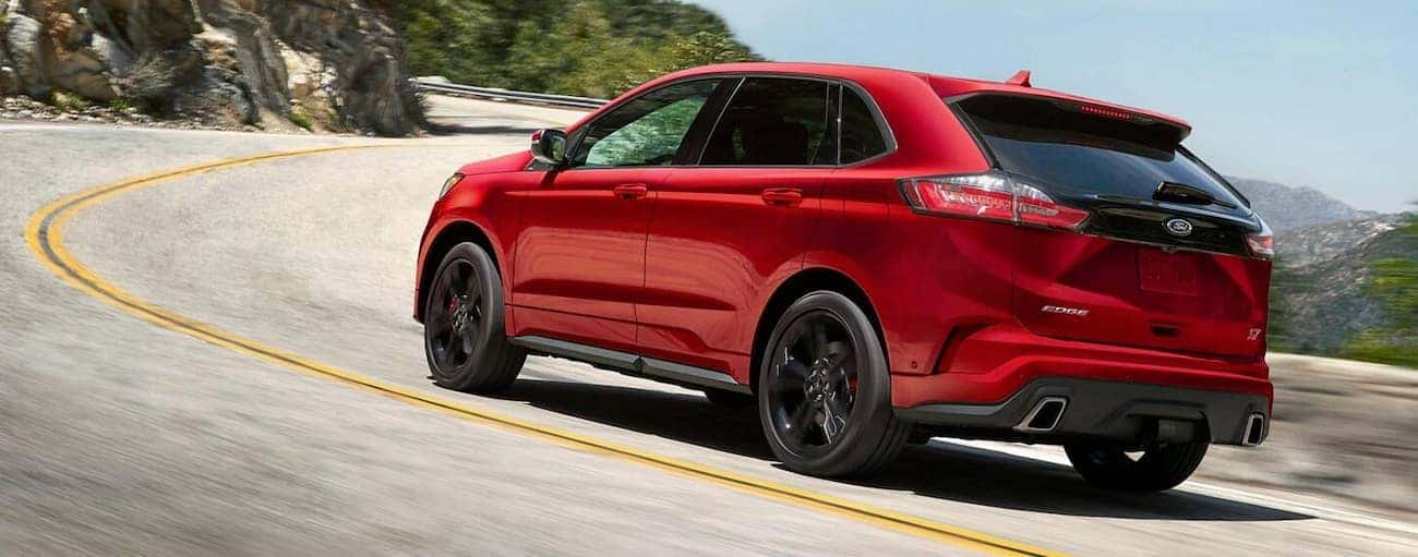 A red 2019 Ford Edge is driving up hill.