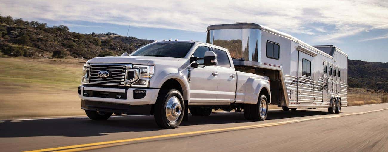 A white 2020 Super Duty Ford F-450 is towing a trailer.