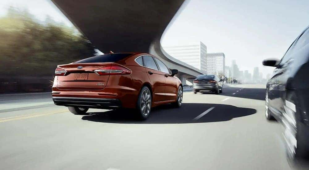 A brown 2019 Ford Fusion, one of the discontinued models as of 2020, is driving under an overpass near Cincinnati, OH.