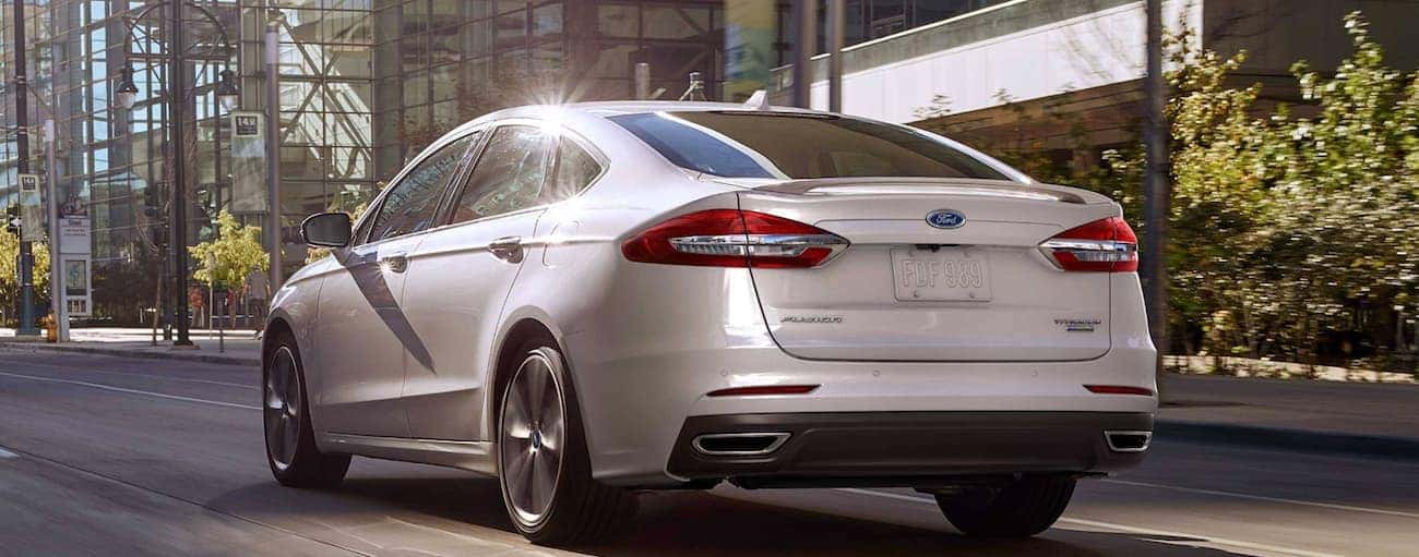 A white 2019 Ford Fusion is driving on a city street near Cinicnnati, OH.