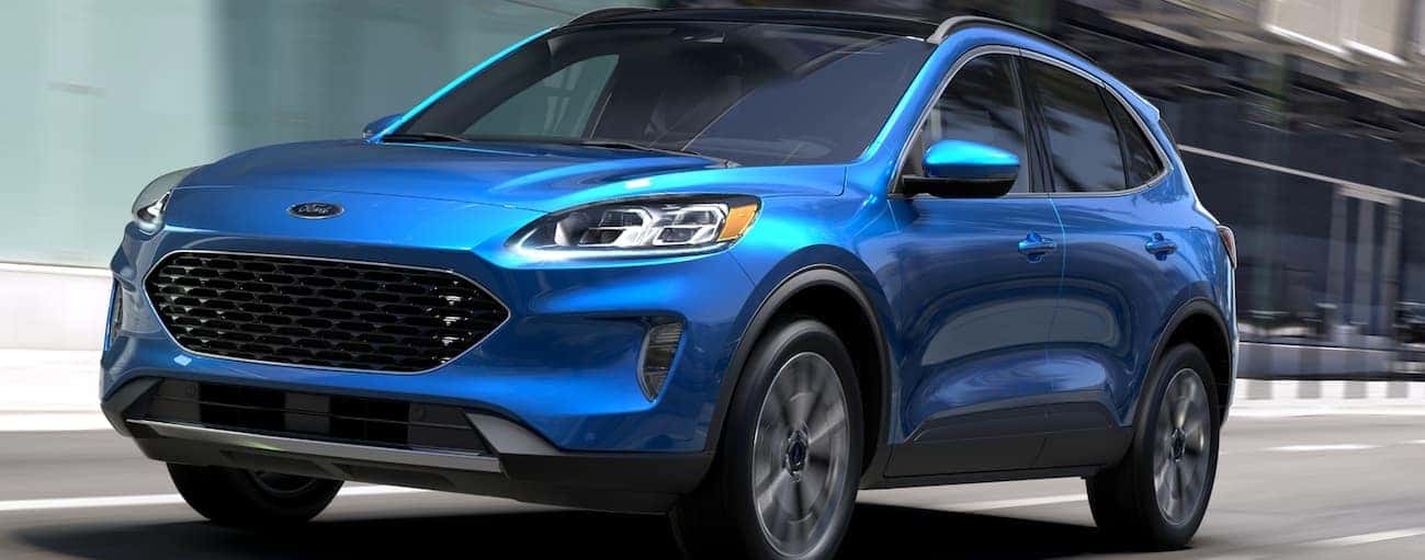 A blue 2020 Ford Escape is driving on a city street near Cincinnati, OH.