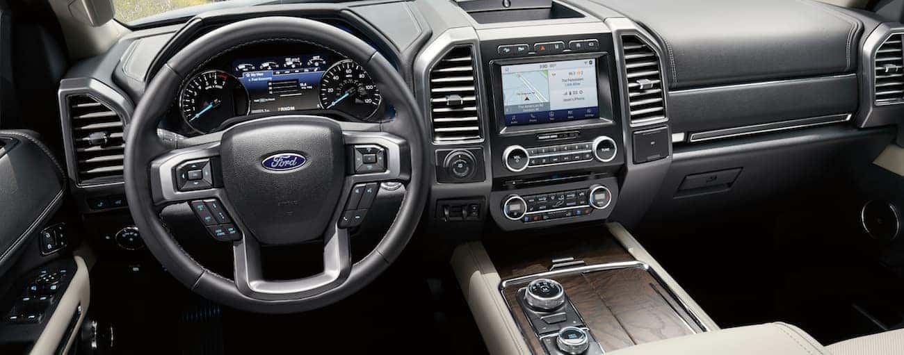 The front tan leather interior of a 2020 Ford Expedition is shown with an infotainment system.