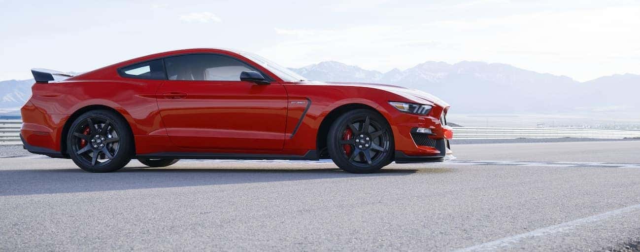 A side view of a red 2020 Ford Mustang Shelby GT350 parked on a track is shown.