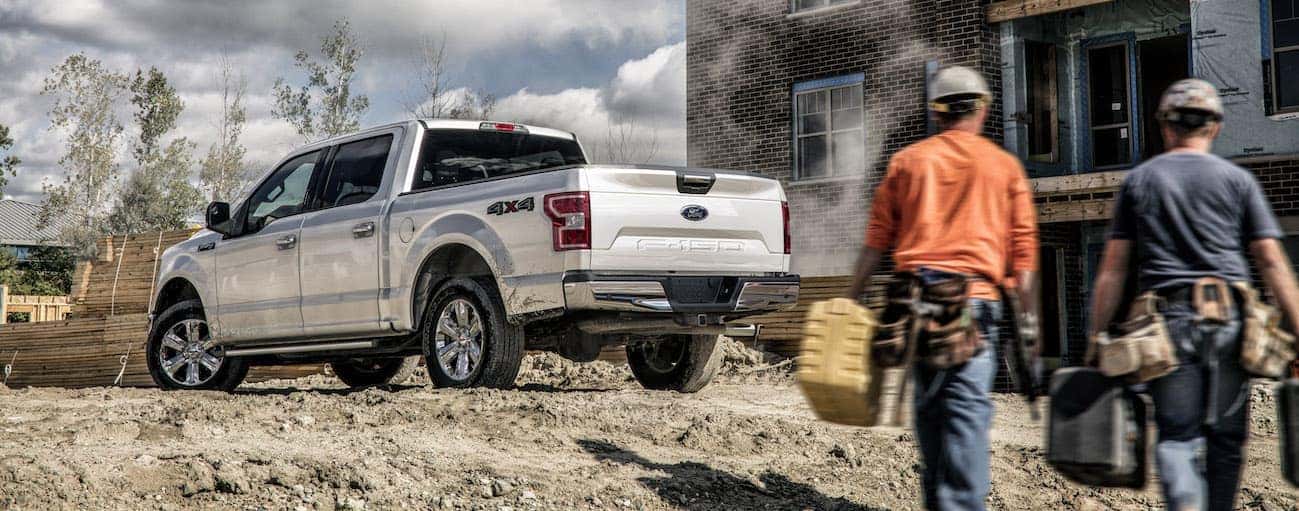 Two Cincinnati, OH construction workers are walking to their silver 2020 Ford F-150.