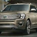 Two men are standing next to a gold 2020 Ford Expedition at a Cincinnati, OH, restaurant at night.