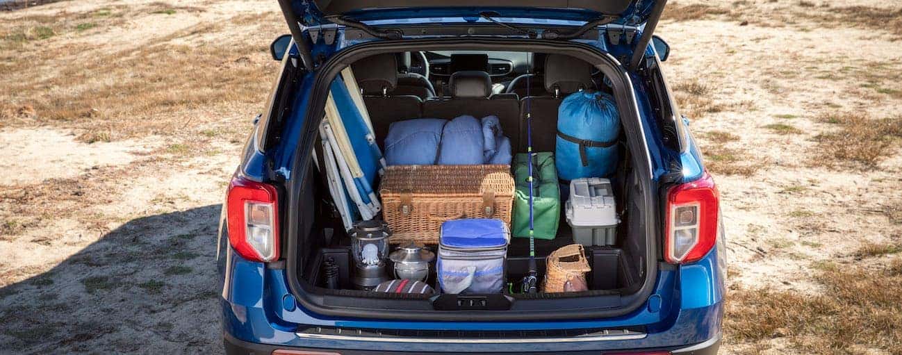 The liftgate of a 2020 Ford Explorer is open while the trunk is full of camping gear is shown.