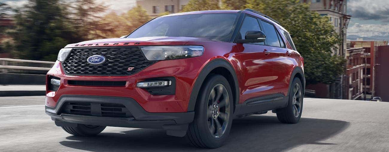 A red 2020 Ford Explorer ST, which wins when comparing the 2020 Ford Explorer vs 2020 Honda Pilot, is driving on a bridge near Cincinnati, OH.