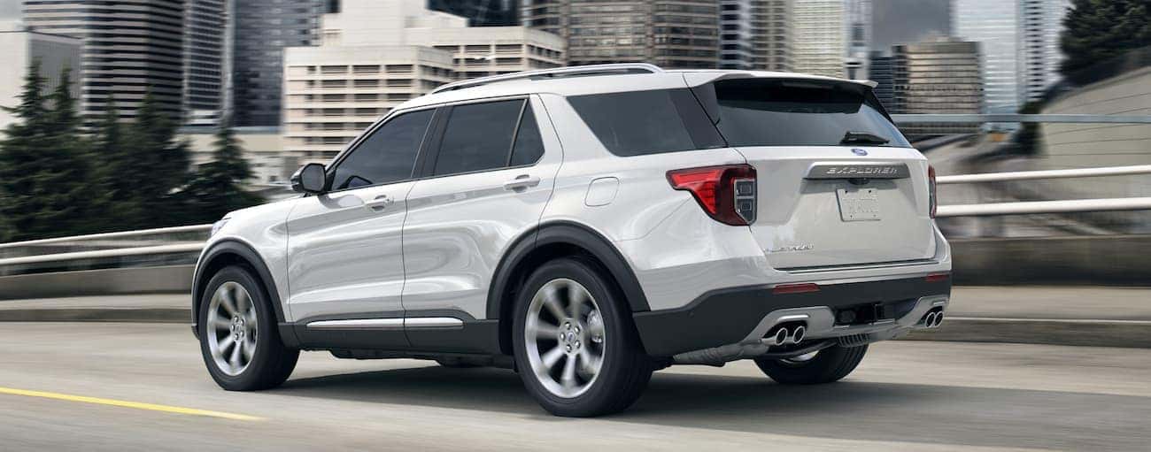 A white 2020 Ford Explorer, which wins when comparing the 2020 Ford Explorer vs 2020 Toyota Highlander, is driving on a bridge near Cincinnati, OH.