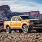 An orange 2019 Ford Ranger is parked in front of rock formations.