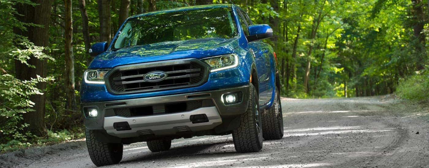 A blue 2020 Ford Ranger is driving on a tree-lined road outside Cincinnati, OH.