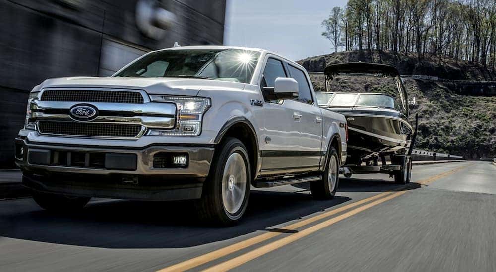 A white 2020 Ford F-150 is towing a boat on a Cincinnati street after leaving one of the Ford dealers in Ohio.